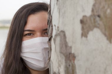 Bayan Covid-19 'dan korunmak için açık havada bir maske tarafından korunuyor. Doğal kaynaklar, ağaçlar ve temiz hava..