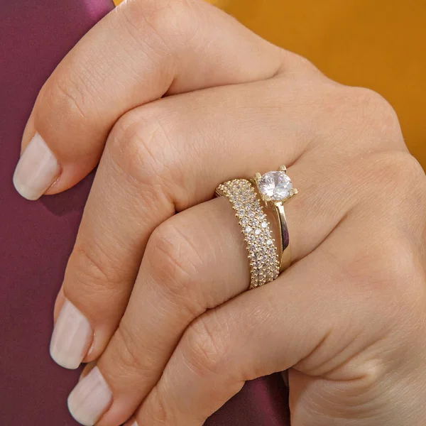 Silver, patterned wedding rings on the female model, different color on the back.
