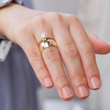 Gümüş, kadın modelinde desenli alyanslar, arkasında farklı renkler..