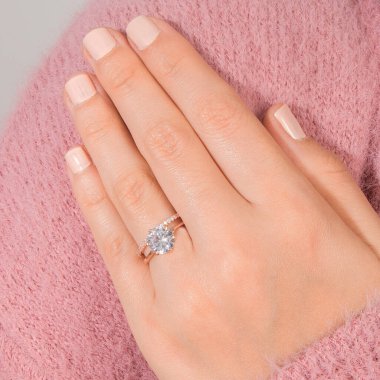 Gümüş, kadın modelinde desenli alyanslar, arkasında farklı renkler..