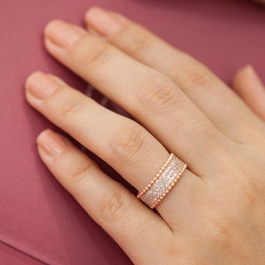 Gümüş, kadın modelinde desenli alyanslar, arkasında farklı renkler..