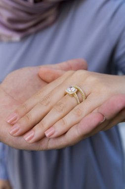 Gümüş, kadın modelinde desenli alyanslar, arkasında farklı renkler..