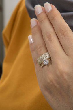 Gümüş, kadın modelinde desenli alyanslar, arkasında farklı renkler..