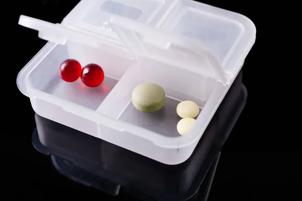 Medical box with pills on a black background