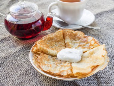 Çaydanlık, bir fincan ve bir plaka üzerinde krep .