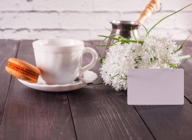 Kahve, macarons bir daire ve bir buket çiçek. bir kart yazıt ile 
