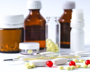 Tıbbi şişe ve hap, beyaz bir arka plan üzerinde termometre