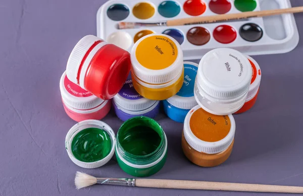 Multicolored jars with paint for paint, brush