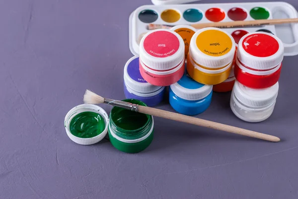 Multicolored jars with paint for paint, brush