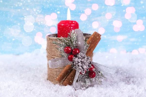 New Year background with a candle on a snowfall background
