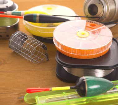 Üç balık tutma ele ve bir kayan nokta, turuncu yuvarlak yemler ve ahşap kurullarında yalan misina kutularını