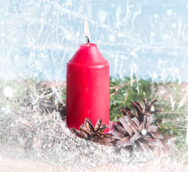 Kırmızı mum, koni ve ahşap arka plan üzerinde şube