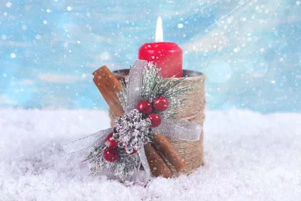 New Year background with a candle on a snowfall background