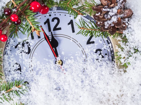 Christmas clock with winter decoration on snow. Happy new year concept