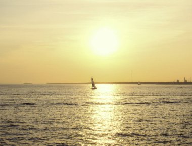 gün batımında denizde yelkenli tekne.