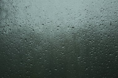 Şiddetli yağmur altında büyük yağmur damlaları olan pencere
