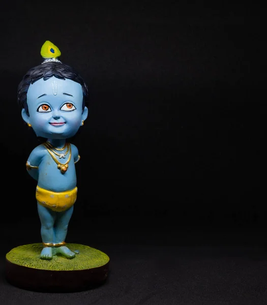 Hindu tanrısı Krishna 'nın sevimli ve masum bir idolü. Siyah arka planı olan ve sol eğilimli bir çocuk. Janmashtami sırasında kutlandı. Düzenlenebilir, afiş, poster