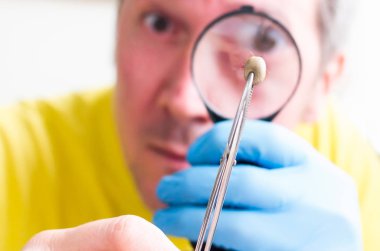 Mite Büyüteç, beyaz arka plan üzerinde izole aracılığıyla bakarak adam.