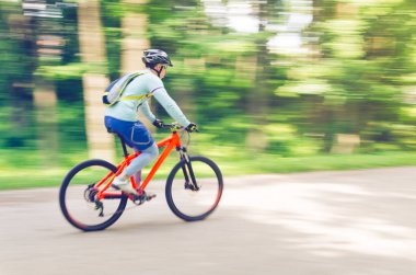 Bir kask bir bisikletçi bir bisiklet yolu, hareket bulanıklığı rides.
