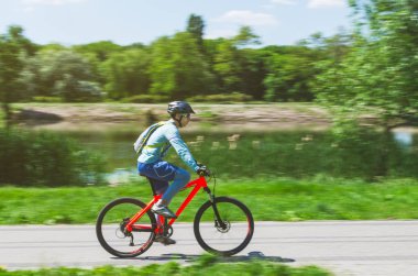 Bir kask bir bisikletçi bir bisiklet yolu, hareket bulanıklığı rides.