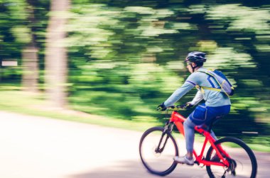 Bir kask bir bisikletçi bir bisiklet yolu, hareket bulanıklığı rides.