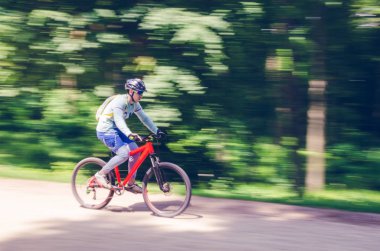 Bir kask bir bisikletçi bir bisiklet yolu, hareket bulanıklığı rides.