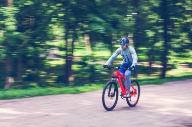 Bir kask bir bisikletçi bir bisiklet yolu, hareket bulanıklığı rides.