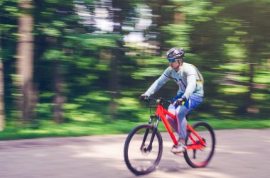 Bir kask bir bisikletçi bir bisiklet yolu, hareket bulanıklığı rides.