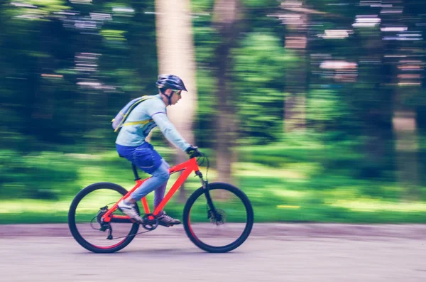 Bir kask bir bisikletçi bir bisiklet yolu, hareket bulanıklığı rides.