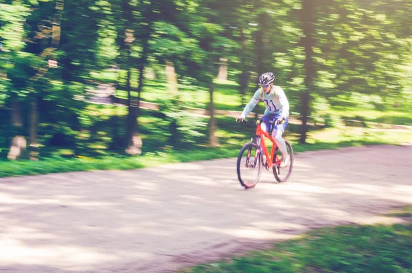Bir kask bir bisikletçi bir bisiklet yolu, hareket bulanıklığı rides.