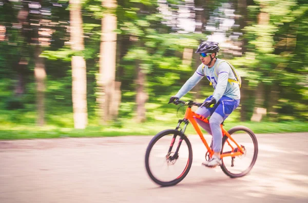 Bir kask bir bisikletçi bir bisiklet yolu, hareket bulanıklığı rides.