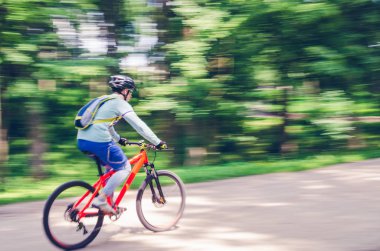 Bir kask bir bisikletçi bir bisiklet yolu, hareket bulanıklığı rides.