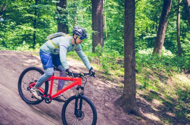 Bir kask bir bisikletçi bir turuncu bisiklet üzerinde dağdan iner.