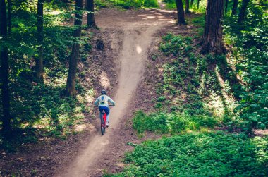 Bir kask bir bisikletçi bir turuncu bisiklet üzerinde dağdan iner.