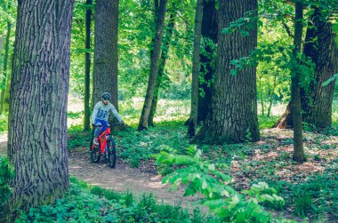 Parkta Binicilik turuncu bisiklet kask bisikletçi.