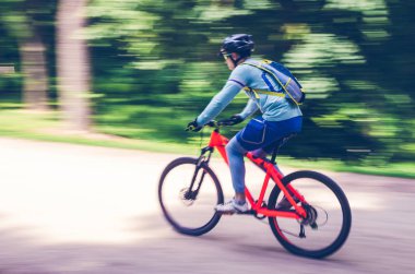 Bir kask bir bisikletçi bir bisiklet yolu, hareket bulanıklığı rides.