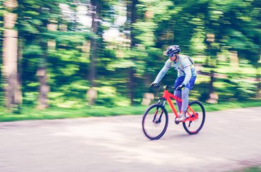 Bir kask bir bisikletçi bir bisiklet yolu, hareket bulanıklığı rides.
