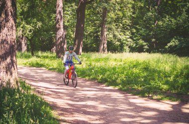 Parkta Binicilik turuncu bisiklet kask bisikletçi.