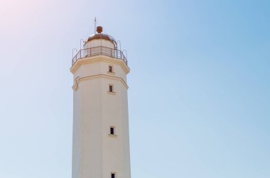 Mavi gökyüzü güneşli bir beyaz deniz feneri.