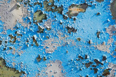 Eski paslı metal bir plaka üzerinde mavi boya kırık.