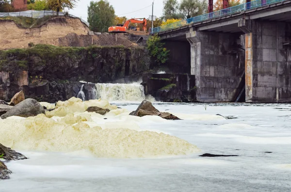 Foam on the surface of the water as a result of the discharge of water from the dam.