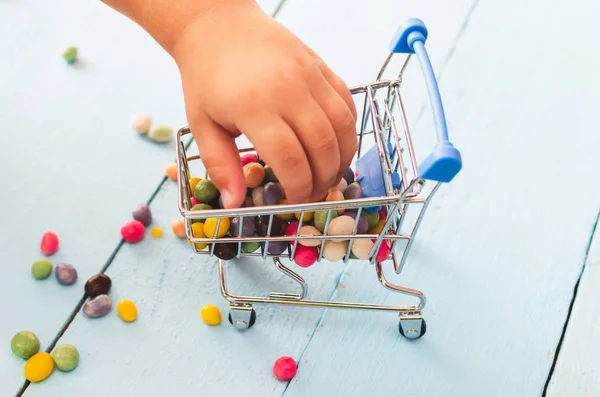 Manos Niño Sosteniendo Carrito Compras Con Dulces Colores Sobre Fondo — Foto de Stock