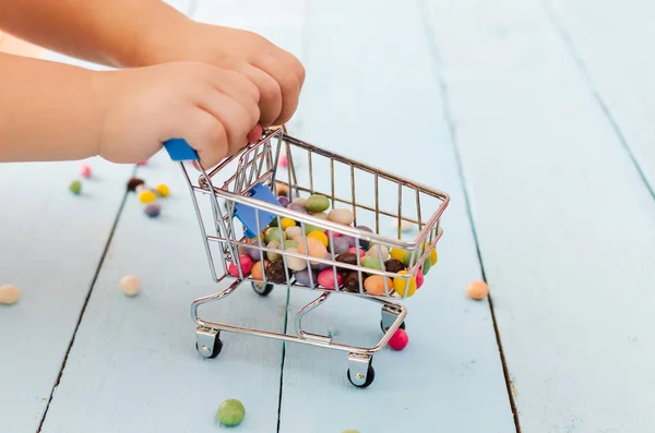 Manos Niño Sosteniendo Carrito Compras Con Dulces Colores Sobre Fondo — Foto de Stock