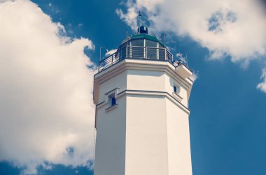 Mavi gökyüzü güneşli bir beyaz deniz feneri.