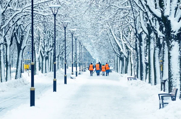 Silecekler Turuncu Yelekler Karlı Bir Sokak Yürüyor — Stok fotoğraf