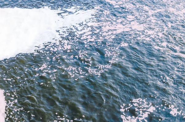 Polluted river, foam on the surface of the water.