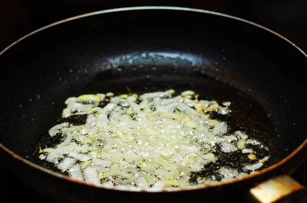 Frying chopped onions in a pan, cooking.