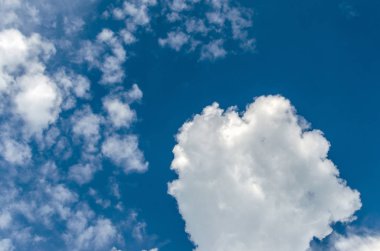 Güzel kabarık bulutlar mavi gökyüzüne karşı.