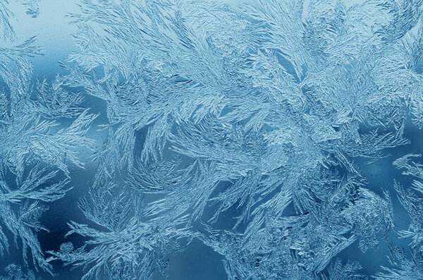 Абстрактный ледяной узор на стекле, текстура фона.