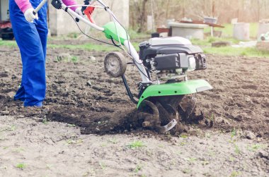 Genç kız bir bahar bahçesinde bir Kültüvatör ile çalışma.